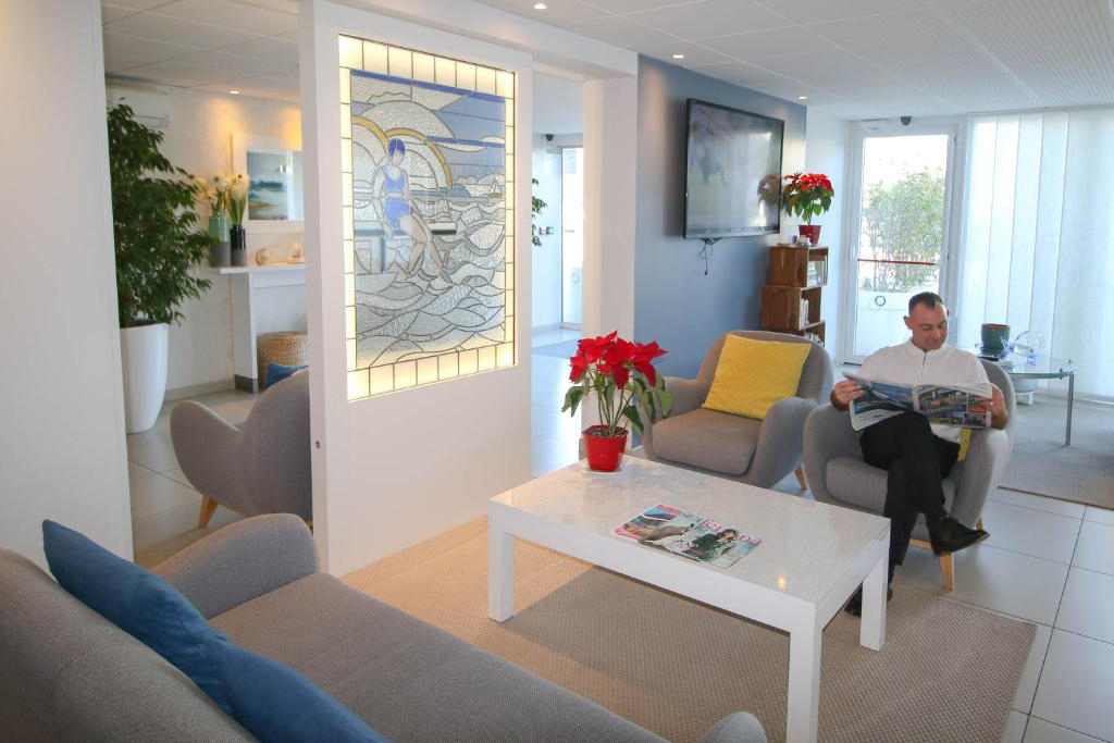 Bright lobby of Hotel Josse with modern seating, a white coffee table, and coastal‑inspired décor.